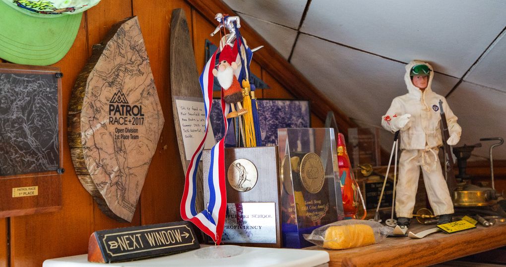 Lowell Skoog keeps a collection of ski memorabilia at his Seattle home. The items include a green cap (upper left) that belonged to his late brother, Carl; two plaques from victorious Mountaineers Patrol Races; and a wooden ski tip given to Lowell by Seth Waterfall, a climbing guide at Mount Rainier. Waterfall found the ski tip on the Muir Snowfield in late summer a few years back. It probably dates from the 1930s or ’40s. Also in the collection are a G.I. Joe on skis from Lowell’s childhood, a Twinkie because he thought they were going to be discontinued, and an old camping stove that belonged to his father during the 1960s. (Mike Siegel/The Seattle Times)
