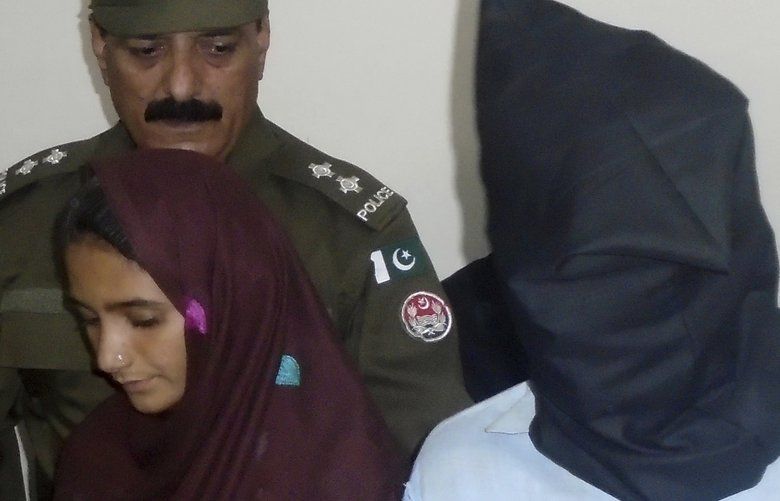 In this Monday, Oct. 30, 2017 photo, 21-year-old Aasia Bibi and her boyfriend, Shahid Lashari, are presented to journalists, at police station in Muzaffargarh in Pakistan. Pakistani police arrested Bibi, a newly married woman, who was married against her will in September, on murder charges after she allegedly poisoned her husband’s milk and it inadvertently killed 17 other people in a remote village. (AP Photo/Iram Asim) ISL105 ISL105