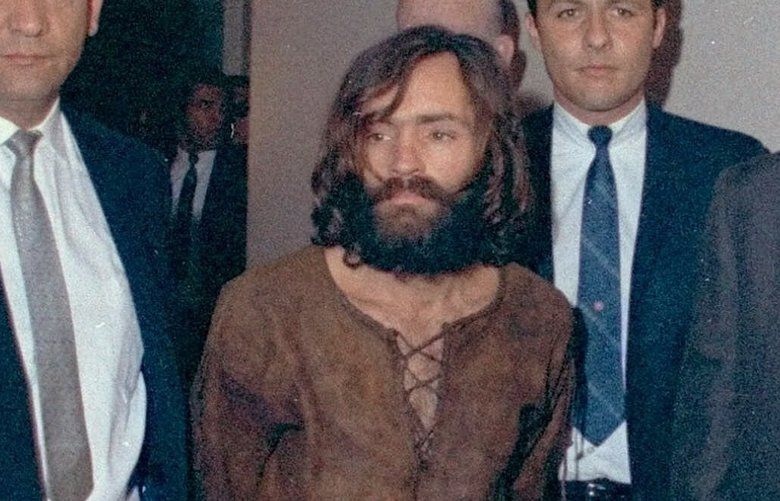 ADVANCE FOR WEEKEND AUG. 7-8–FILE–Charles Manson is escorted to and from Los Angeles Court December 11, 1969 for arraignment on conspiracy charges in connection with the slayings of actress Sharon Tate and seven others. Thirty years later, the ghosts of the Tate-La Bianca murders will not rest. The Charles Manson cult that carried them out haunts the Internet and a new generation is oddly fixated on the nation’s most bizarre and notorious killings. (AP Photo/File)