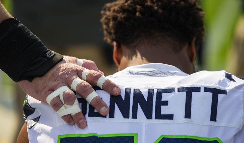 Michael Bennett, all Seahawks, stand for the national anthem on Salute to  Service night vs. Atlanta