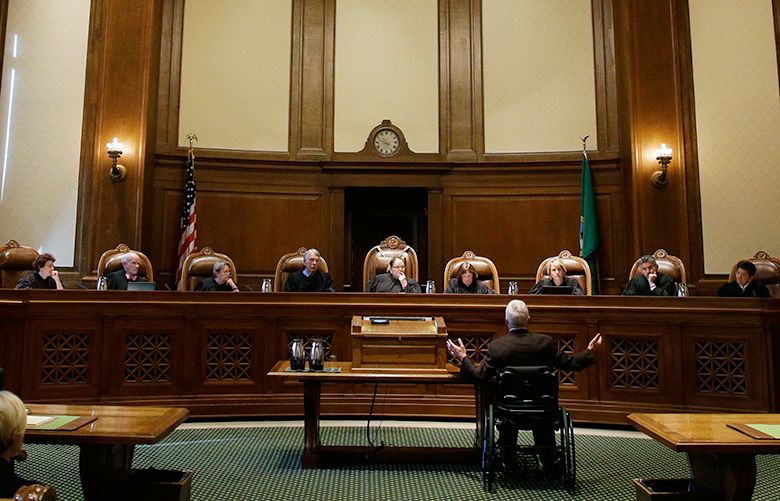 Tom Ahearne, center-right, the lead attorney in a lawsuit against the state of Washington regarding the funding of education, gestures as he speaks Tuesday, Oct. 24, 2017, during a Washington Supreme Court hearing in Olympia, Wash. The hearing was held to determine if Washington state has complied with a court mandate to fully fund the state’s basic education system. (AP Photo/Ted S. Warren)