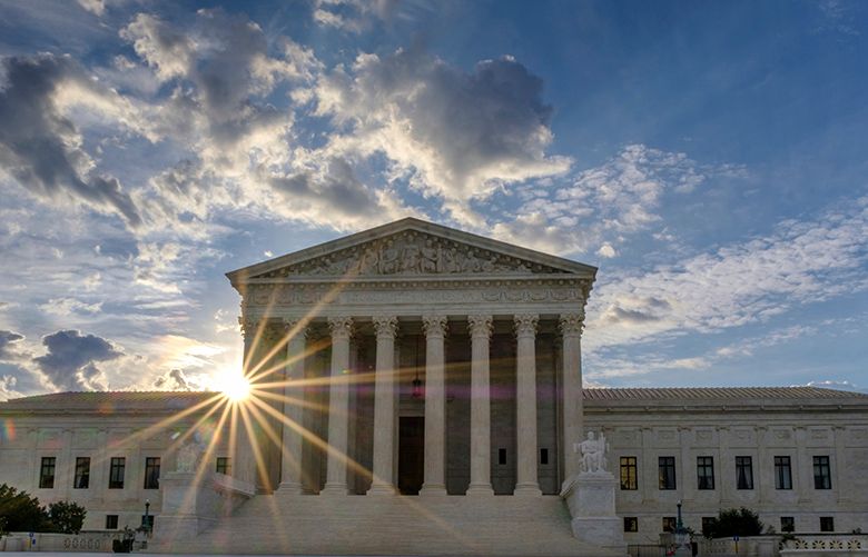 The sun flares in the camera lens as it rises behind the U.S. Supreme Court building in Washington, Sunday, June 25, 2017. The court is expected to decide within days if the Trump administration can enforce it’s travel ban. (AP Photo/J. David Ake)