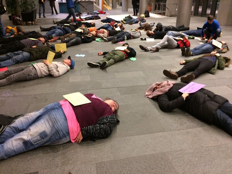 Activists stage a “die-in” at Seattle City Hall Thursday, representing the homeless who have died this year. (Christine Clarridge / The Seattle Times)