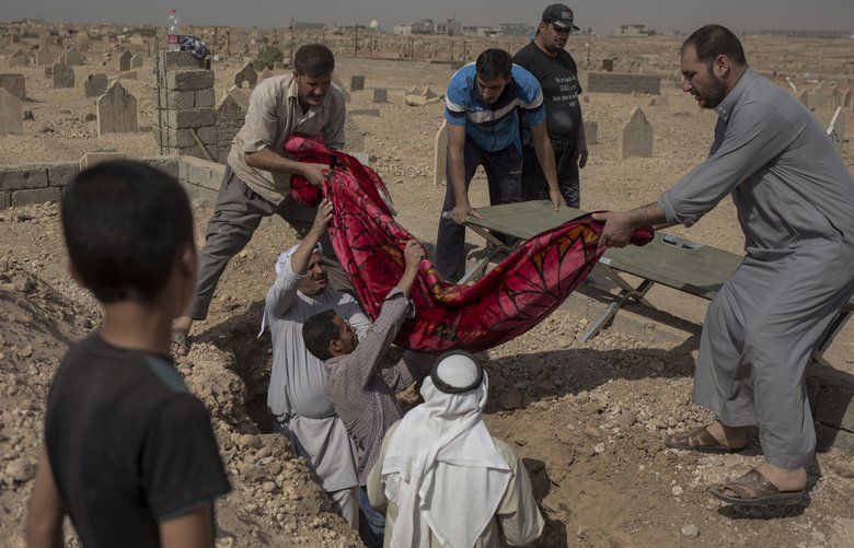 In this Oct. 9, 2017 photo, relatives bury the body of 15-year-old Sana Younes at a graveyard in Mosul. Under Iraqi law, Mosul residents have to exhume the bodies of their relatives in order to receive a death certificate from the government, after which the remains are reburied. An AP investigation found between 9,000 and 11,000 civilians died during the final battle to drive out Islamic State extremists, and many of those deaths are only now being recorded. (AP Photo/Bram Janssen) XBJ508 XBJ508
