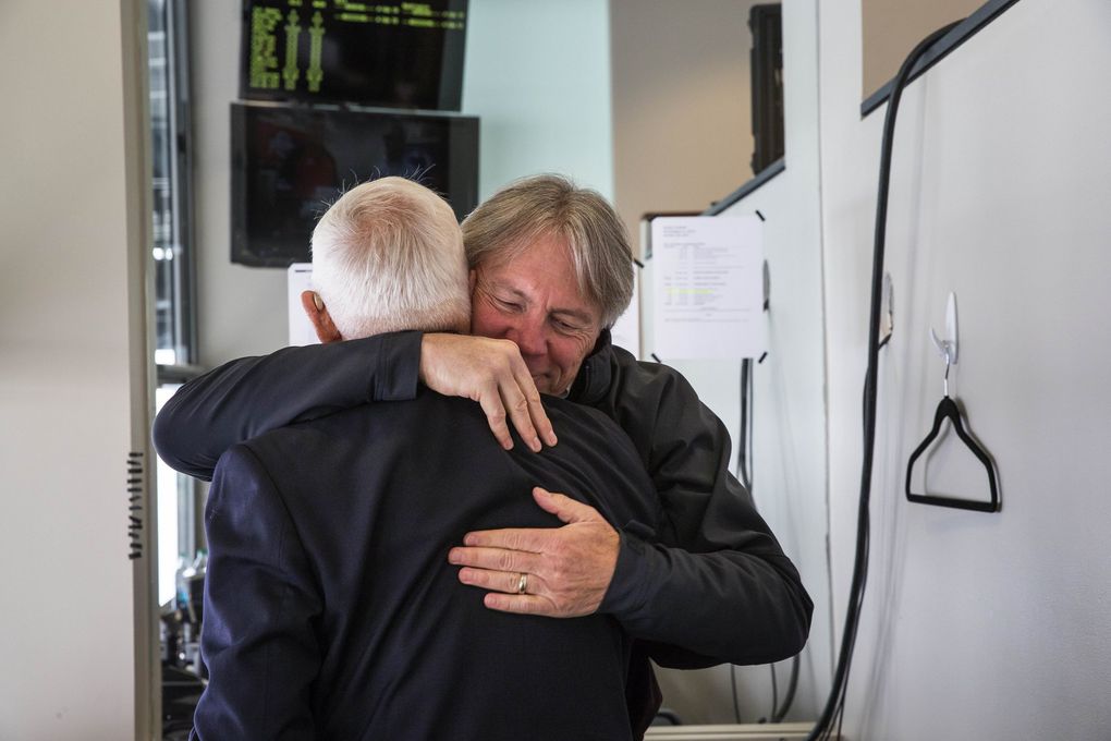 Bod Rondeau gets a warm hug goodbye from former Washington Athletic Director Mike Lude who came to see him in the broadcast booth. (Dean Rutz / The Seattle Times)