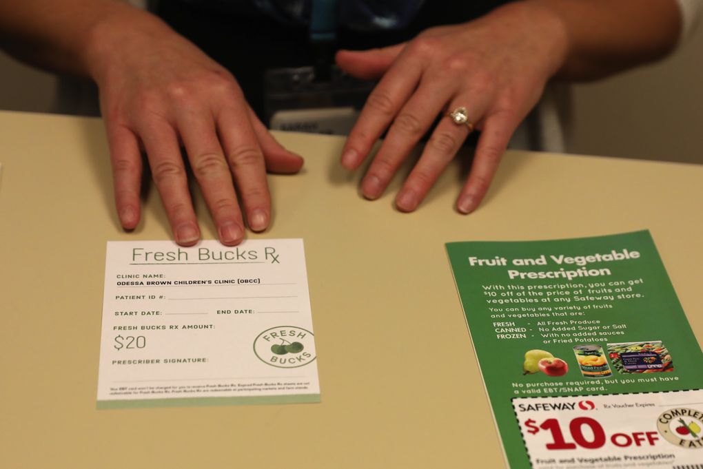 A Fresh Bucks Rx voucher, at left, helps patients at Seattle’s Odessa Brown Children’s Clinic buy fresh produce. The program will get funds from the sugary-drinks tax. (Ken Lambert/The Seattle Times)