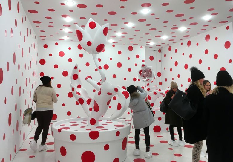 People use their smartphones to take pictures of the Yayoi Kusama