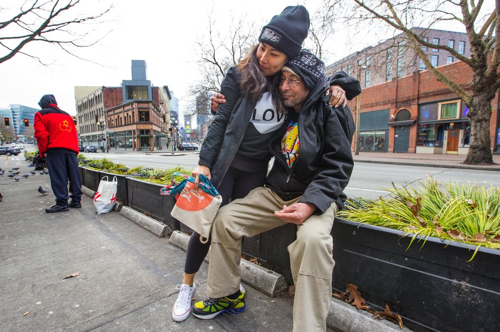 Nurse Amy Han, 32, gives Santokh Singh a hug after offering him a sandwich and a bottle of water. Han says it’s meant as more than a meal; it’s a message of caring. (Mike Siegel/The Seattle Times)