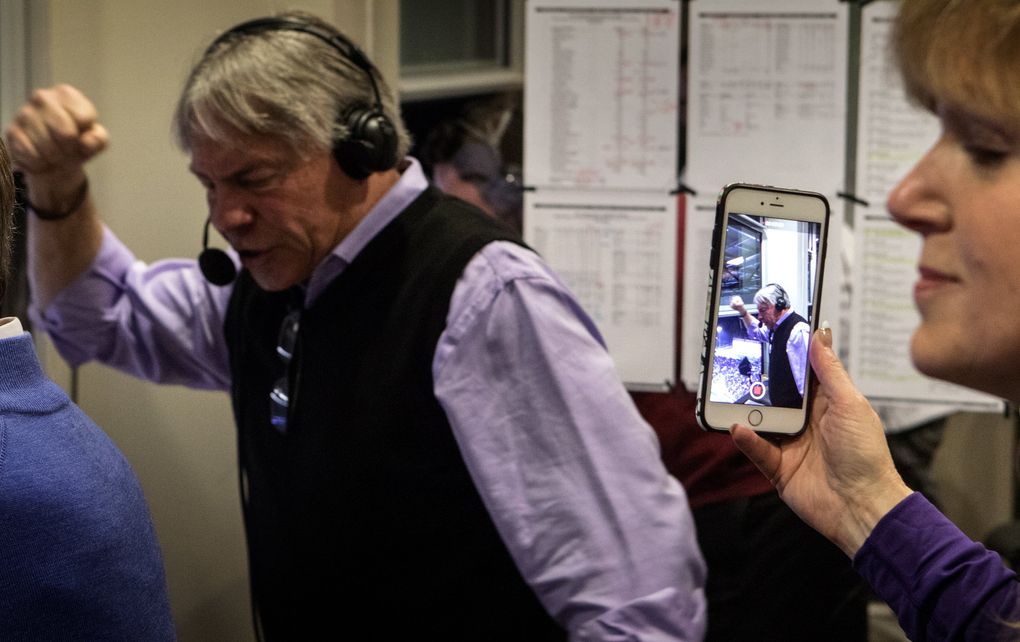 Molly Rondeau, wife of Bob Rondeau, shoots a video of her husband as he calls the first UW touchdown of the 110th Apple Cup. (Ellen M. Banner / The Seattle Times)