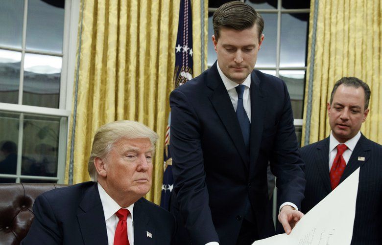 FILE – In this Jan. 20, 2017 file photo, White House Staff Secretary Rob Porter, center, hands President Donald Trump a confirmation order for James Mattis as defense secretary, in the Oval Office of the White House in Washington, as White House Chief of Staff Reince Priebus, right, watches.  Porter is stepping down following allegations of domestic abuse by his two ex-wives.   (AP Photo/Evan Vucci) WX102 WX102