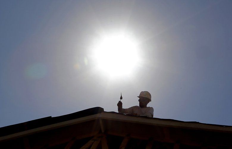 FILE – In this July 25, 2014 file photo, a roofer works under the mid-day sun in Gilbert, Ariz. Federal science officials announced Friday that for the third time in a decade, the globe sizzled to the hottest year on record. Both the National Oceanic and Atmospheric Administration and NASA calculated that in 2014 the world had its hottest year in 135 years of record-keeping. Earlier, the Japanese weather agency and an independent group out of University of California Berkeley also measured 2014 as the hottest on record. (AP Photo, File)