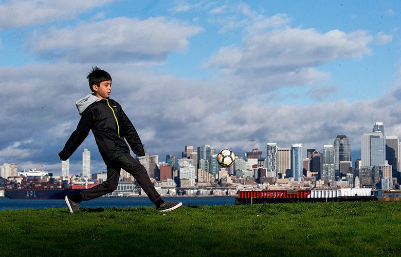 Desmond Desierto, 9, practices his soccer skills at Seacrest Park overlooking Seattle’s skyline, on Sunday, Feb. 4, 2018.