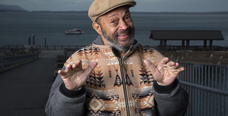 Thom Bell, a Hall of Fame songwriter and music producer with more than 30 gold records, lives in Bellingham, in the hills above Chuckanut Drive. Here, with Bellingham Bay in the background, Bell shows how he used to start playing piano as a young boy in Philadelphia. (Steve Ringman/The Seattle Times)