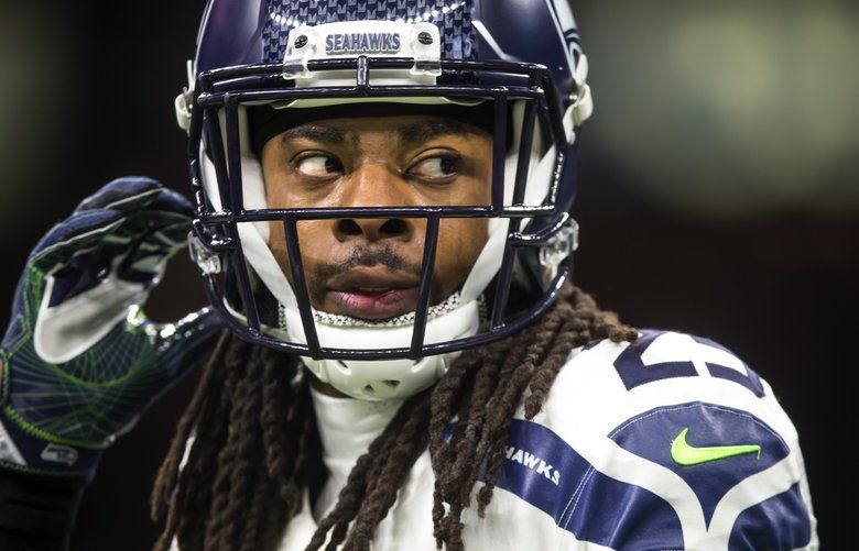 Seattle Seahawks cornerback Richard Sherman wears a mask to stay warm  during warmups before an NFL football game against the Los Angeles Rams,  Thursday, Dec. 15, 2016, in Seattle. (AP Photo/Elaine Thompson