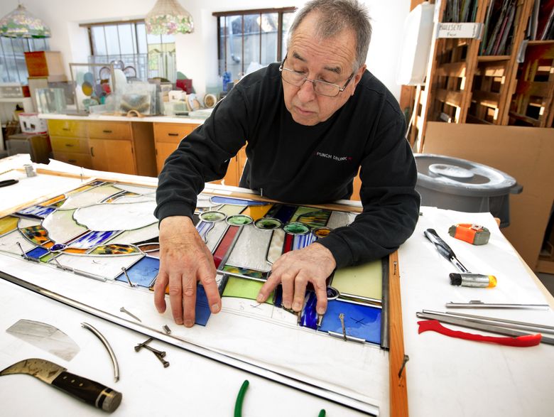 Glassworks founder and designer Steve Shahbaghlian works on a leaded-glass window. (Mike Siegel/The Seattle Times)