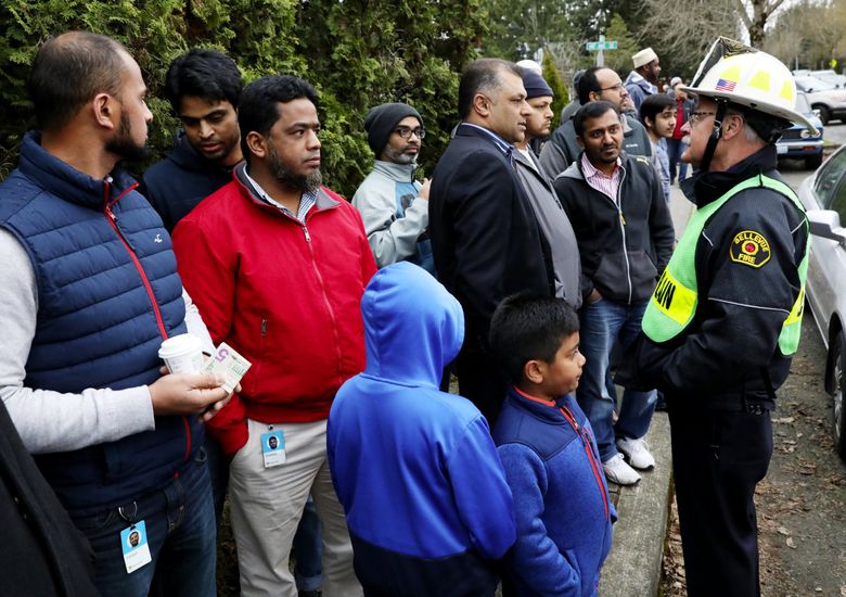 Fire chaplain Mike Ryan, right, offers support to board members of the Islamic Center of Eastside, who gather after their mosque was hit with a fire on Wednesday in Bellevue. (Ken Lambert / The Seattle Times)