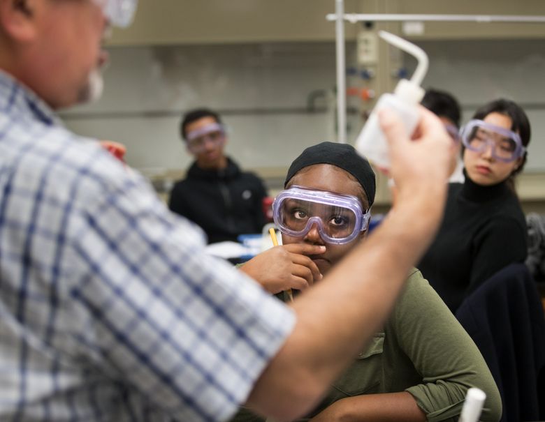 Nia Hall, a Running Start student from Garfield High School, takes most of her classes at Seattle Central College, where she starts her day at 8 a.m. Hall, center, and Suhyun Park, right, listen as Esmaeel Naeemi explains a chemistry-lab lesson at Seattle Central College.  (Mike Siegel/The Seattle Times)