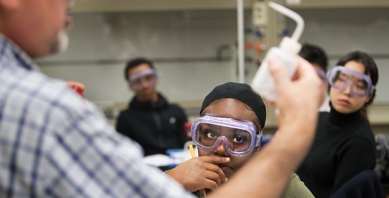 Nia Hall, a Running Start student from Garfield High School, takes most of her classes at Seattle Central College where she starts her day at 8am. Hall, center, and  Suhyun Park, right, listen to Professor Esmaeel Naeemi explain a chemistry lab lesson at Seattle Central College. 

Photographed on November 30, 2017.

 204377
