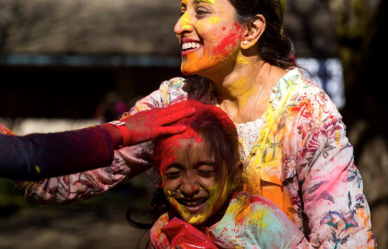 Nirupa Varadarajan and Diya Naidu share color with each other during a Holi celebration at Lake Sammamish State Park in Issaquah on Sunday, March 11, 2018. The holiday is also known as the “festival of colors” and is celebrated annually across India and Nepal.