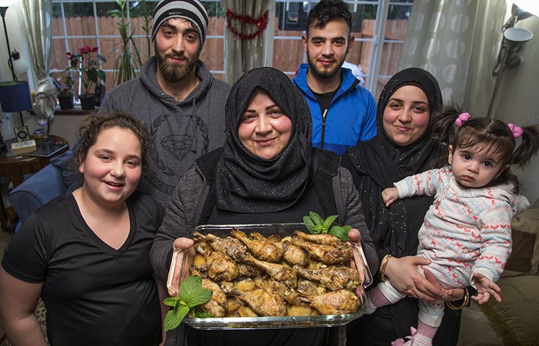 Wed. Feb. 28, 2018.   Emtisal Bazara, center, and family escaped from Syria and spent years as refugees in Jordan and Turkey are finally here in the US.  Emtisal makes a dish of Chicken and Potatoes.  Her family from left, Alaa, 12, Walid, 22, Mohmad, 19, Jidaa, 24 and granddaughter Ayla Mohmad, 10 months.