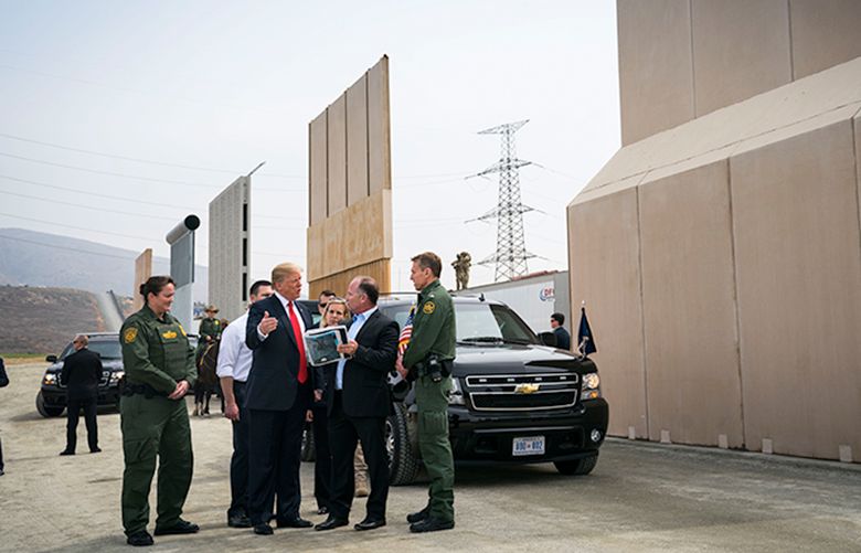 FILE– President Donald Trump views border wall prototypes in the border neighborhood of Otay Mesa near San Diego, March 13, 2018. Trump has called for a wall along the border with Mexico to stop undocumented immigrants and drugs from entering the U.S. But Border Patrol agents on the front lines say they need more technology and additional personnel to curb the illegal traffic, according to a report released on Thursday by Democrats on the Senate Homeland Security Committee. (Doug Mills/The New York Times)