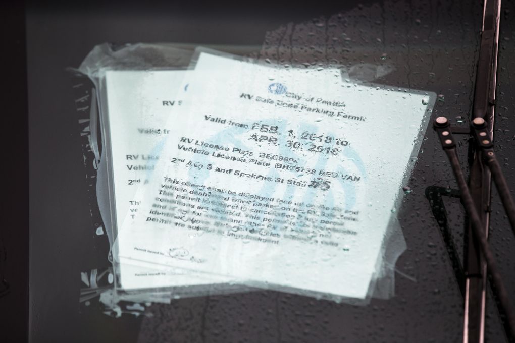 Permits are displayed in the windshield of one of eight recreational vehicles remaining in the City of Seattle’s last safe parking zone. Permitted residents who live in vehicles can park at the Sodo site without fear of being ticketed or towed. But no new permits are being issued. (Bettina Hansen/The Seattle Times)