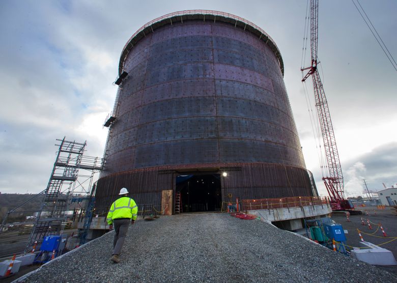 Jim Hogan walks toward the entrance of the tank being built to hold 8 million gallons of liquefied natural gas at the Tacoma LNG plant. (Ellen M. Banner/The Seattle Times)
