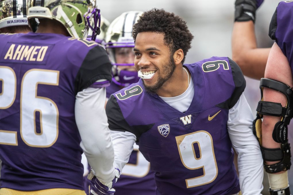 Huskies running back Myles Gaskin, who didn’t play, congratulates Salvon Ahmed on his touchdown during Saturday’s spring scrimmage at Husky Stadium. (Dean Rutz/The Seattle Times)