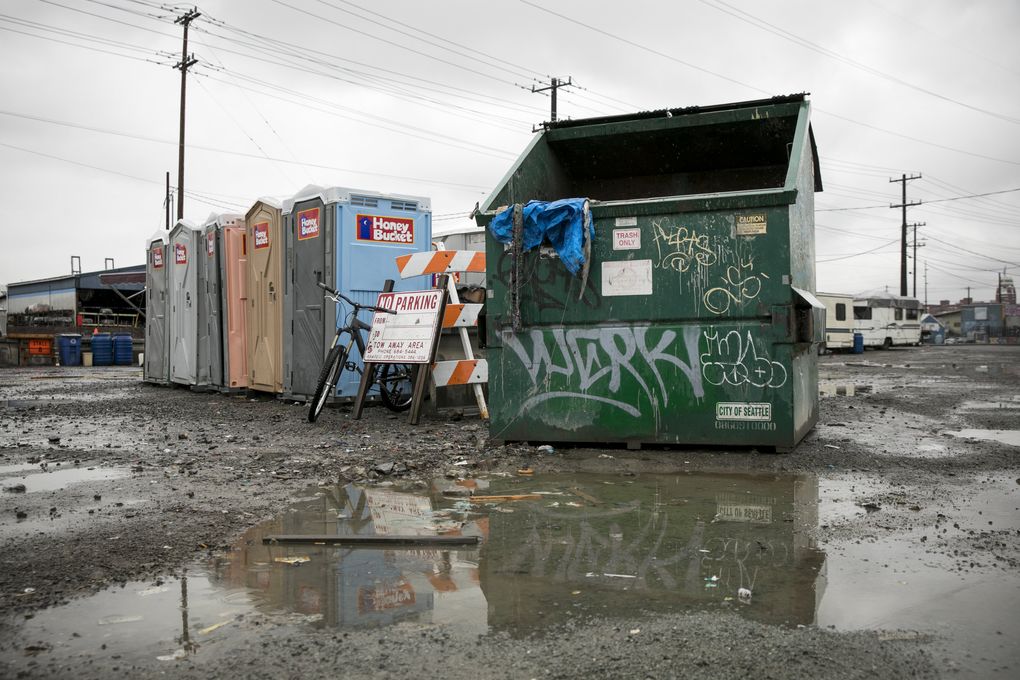 Portable toilets and a dumpster are the amenities at the city of Seattle’s last parking zone for people who live in vehicles. Permitted residents who live in RVs can park at the site without fear of being ticketed or towed. It’s only temporary, but it’s not clear when the lot will close. (Bettina Hansen/The Seattle Times)