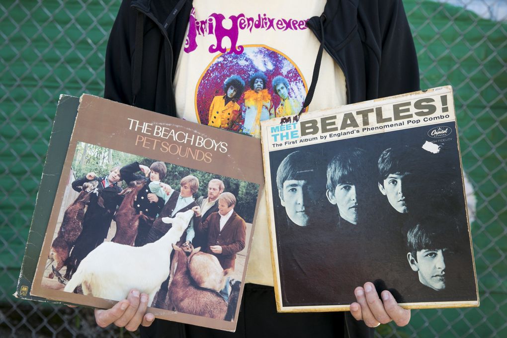 Dan Hughes, tasked with taking the Storm to the next level, shows off two of his favorite records by The Beach Boys and The Beatles while wearing his Jimi Hendrix t-shirt at Daybreak Records in the Fremont neighborhood. (Bettina Hansen/The Seattle Times)