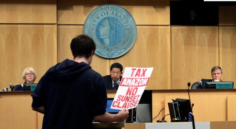City council members Sally Bashaw, left, President Bruce Harrell and Mike O’Brien look on as a man testifies at a Seattle City Council meeting where the council was expected to vote on a “head tax” Monday, May 14, 2018, in Seattle. The council is to vote on a proposal to tax large businesses such as Amazon and Starbucks to fight homelessness. The plan would tax large businesses about $500 a year per worker to raise about $75 million a year for homeless services and affordable housing. (AP Photo/Elaine Thompson)