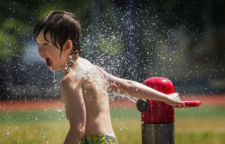 Five-year-old Wescott Danilson from Seattle sprays himself in the waterpark at Georgetown Playfield in Seattle’s Georgetown neighborhood Monday, May 28, 2018.  He was there with his mom and sister enjoying the beautiful sunshine.