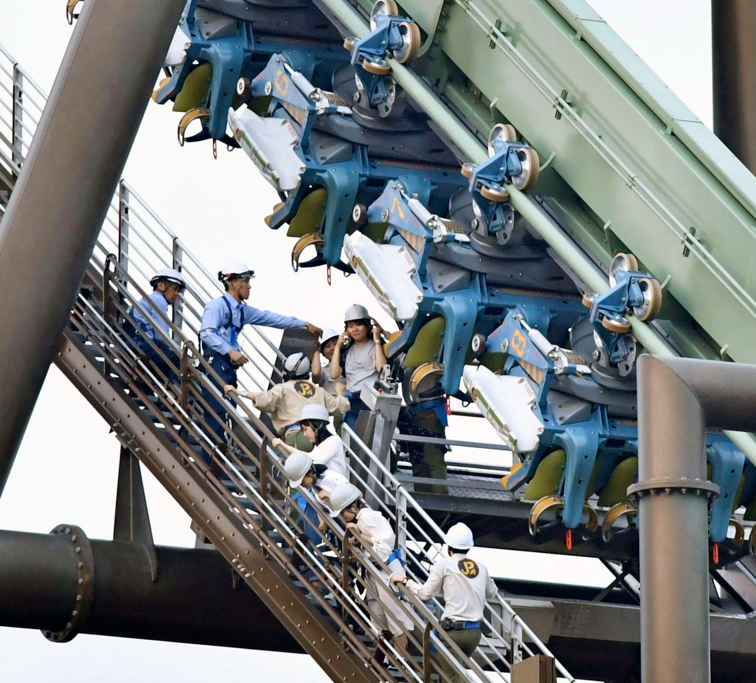 Universal Studios Japan coaster stalls with riders hanging The