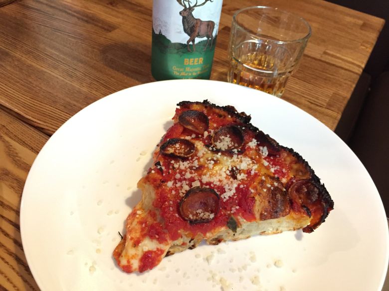 A slice of Breezy Town pepperoni plus Clock-Out Lounge’s drink special equals Beacon Hill happiness.  (Bethany Jean Clement / The Seattle Times)