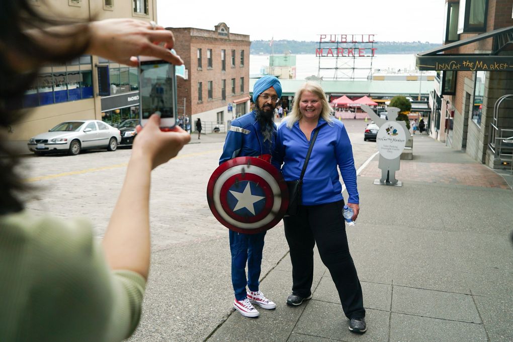 Vishavjit Singh poses for a photo with Katie Zunich, a tourist from San Diego, in front of Pike Place Market. (Corinne Chin / The Seattle Times)