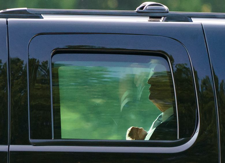 President Donald Trump is seen through the window of his motorcade vehicle as he is driven to board Martine One at Walter Reed National Military Medical Center in Bethesda, Md., Tuesday, May 15, 2018, en route to Washington. The White House says first lady Melania Trump is hospitalized after undergoing a procedure to treat a benign kidney condition. (AP Photo/Carolyn Kaster)