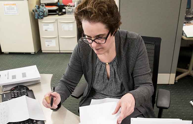 Jeanine Lazili, an administrative assistant at Sun Life Financial in Wellesley, Massachusetts, enjoys the detailed work of document preparation and the camaraderie of the office. (Kayana Szymczak / The New York Times)