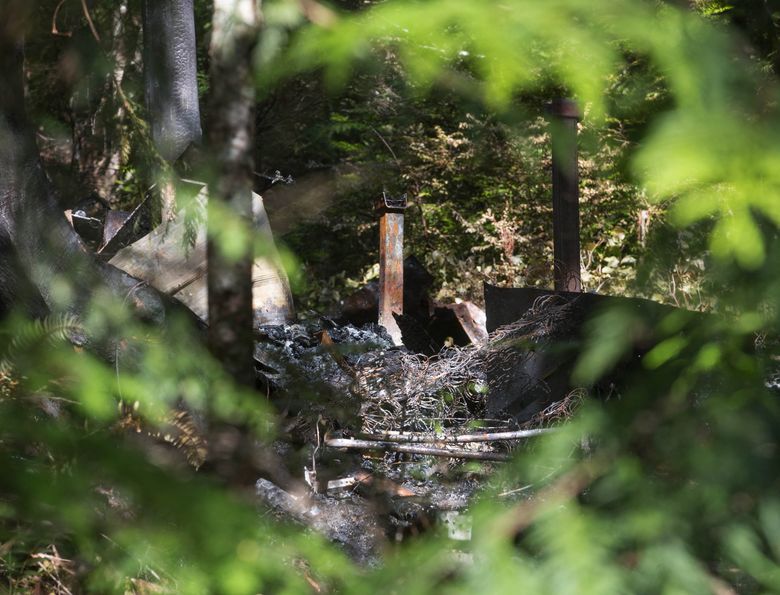 A view of the charred remains of a Hood Canal cabin where a weekend explosion and fire left five people dead.  (Mike Siegel / The Seattle Times)