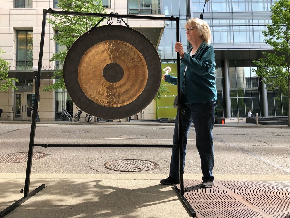 Sally Kinney sounds a gong outside Seattle City Hall on Tuesday to recognize people living without shelter and to protest income inequality. (Mike Siegel / The Seattle Times)