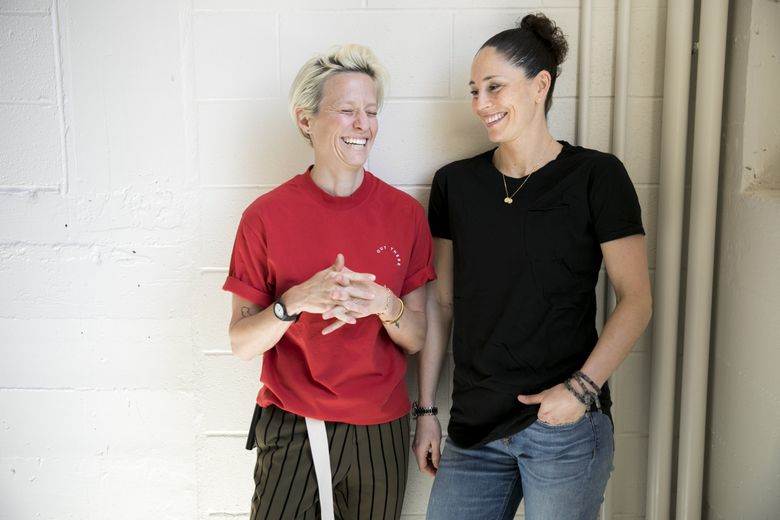 Megan Rapinoe of Reign FC, left, and Sue Bird of the Seattle Storm are the new power couple of the Seattle sports world, each with a long list of national and international accolades to her name. (Bettina Hansen / The Seattle Times)