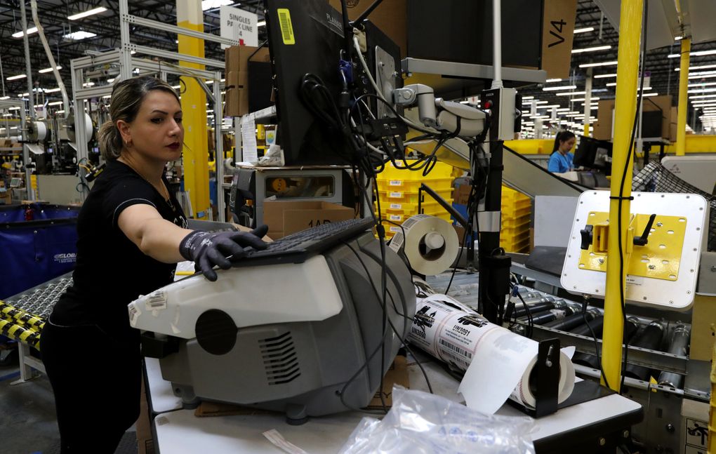 It’s a fast-paced job for Kent workers who ensure orders are filled quickly. (Alan Berner / The Seattle Times)