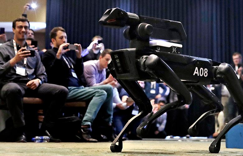 In this Thursday, May 24, 2018, photo, a Boston Dynamics SpotMini robot is walks through a conference room during a robotics summit in Boston. It’s never been clear whether robotics company Boston Dynamics is making killing machines, household helpers, or something else entirely. But the secretive firm, which for nine years has unnerved viewers with YouTube videos of robots that jump, gallop or prowl like animal predators, is starting to emerge from a quarter-century of stealth. (AP Photo/Charles Krupa)