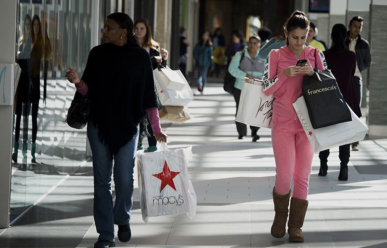 Shoppers carry bags while walking at the Roosevelt Field Mall in Garden City, New York, U.S., on Saturday, Nov. 14, 2015. The Bloomberg Consumer Comfort Index, a survey which measures attitudes about the economy, is scheduled to be released on November 19. Photographer: John Taggart/Bloomberg