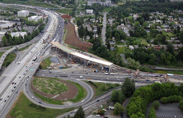 This direct bus-carpool ramp linking Highway 167 to I-405 at Renton will be finished by the end of 2018. In six years, it could become the hub of an express toll lane network from Puyallup to Lynnwood, generating millions to support more projects. This aerial photo, taken May 17, shows I-405 at left and Highway 167 running left to right in the center.  (Greg Gilbert/The Seattle Times)