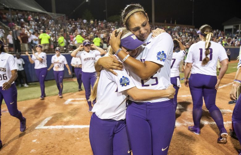 Washington’s Kirstyn Thomas, right, grabs a teammate in a tearful embrace after the Huskies lost the National Championship to Florida State Tuesday in Oklahoma City. (Dean Rutz/The Seattle Times)