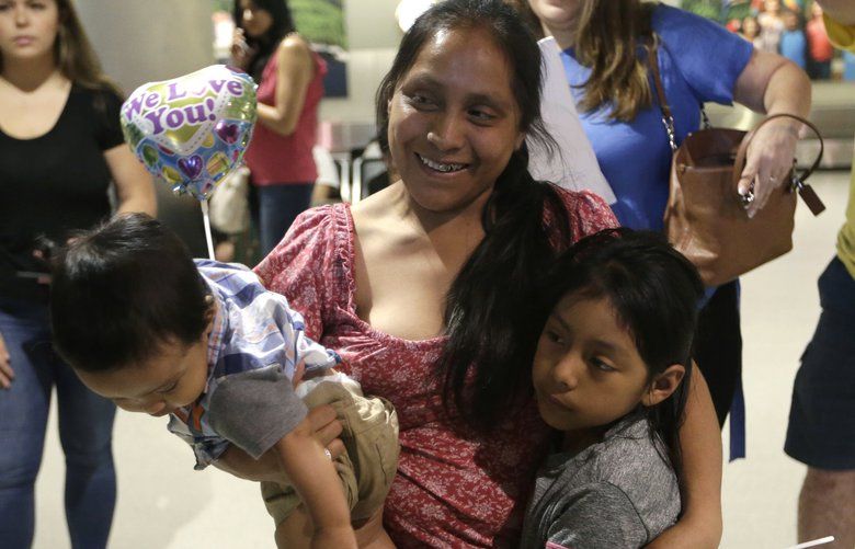 Buena Ventura Martin-Godinez, center, holds her son Pedro, left, as she is reunited with her daughter Janne, right, at Miami International Airport, Sunday, July 1, 2018, in Miami. Martin crossed the border into the United States from Mexico in May with her son, fleeing violence in Guatemala. Her husband crossed two weeks later with their 7-year-old daughter Janne. All were caught by the Border Patrol, and were separated. Her daughter was released Sunday from a child welfare agency in Michigan. (AP Photo/Lynne Sladky) FLLS102 FLLS102