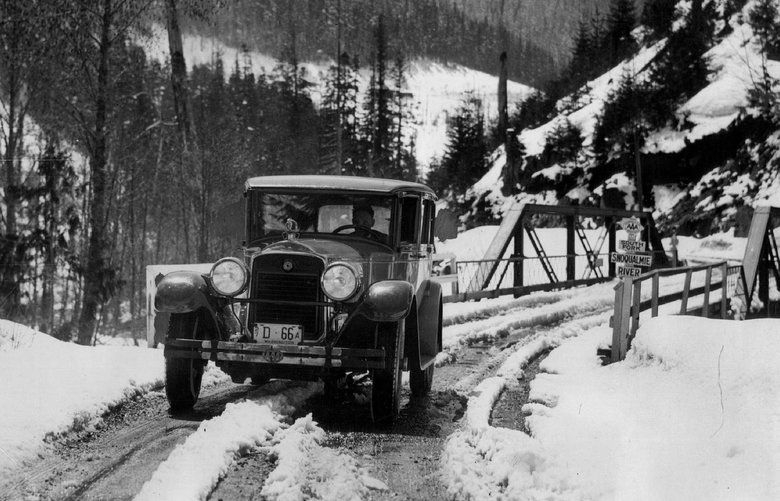 A motorist drove toward Snoqualmie Pass in 1927.
With  the county in debt for work already clone, a curious solution was proposed. The legislature passed an act permitting sale of any individual’s property by lottery, providing 10 per cent of the money went to King County “for the purpose of maintaining a road 30 feet wide from Snoqualmie Prairie to Lake Keechelus as part of a territorial road from Seattle to Walla Walla.” A commission was appointed to locate the road, advertise for bids and let the contract, but before this could be done the scheme was declared illegal.