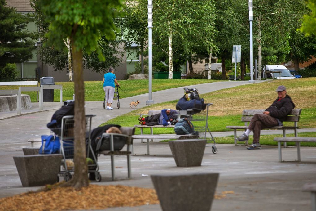 People sleep, sit, and walk in Ballard Commons Park, two blocks north of Northwest Market Street. The park is across the street from St. Luke’s Episcopal Church and the library. (Mike Siegel / The Seattle Times)