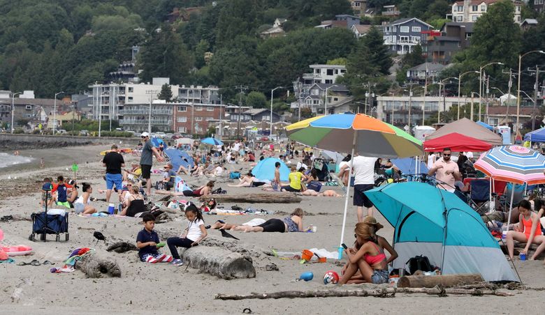 Sunbathers filled Alki Beach last month as Seattle’s summer began. (Greg Gilbert / The Seattle Times)