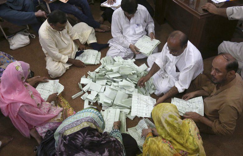 Pakistani election staff count the votes following polls closed at a polling station for the parliamentary elections in Karachi, Pakistan, Wednesday, July 25, 2018. After an acrimonious campaign, polls opened in Pakistan on Wednesday to elect the country’s third straight civilian government, a first for this majority Muslim nation that has been directly or indirectly ruled by its military for most of its 71-year history. (AP Photo/Shakil Adil) ANJ119 ANJ119